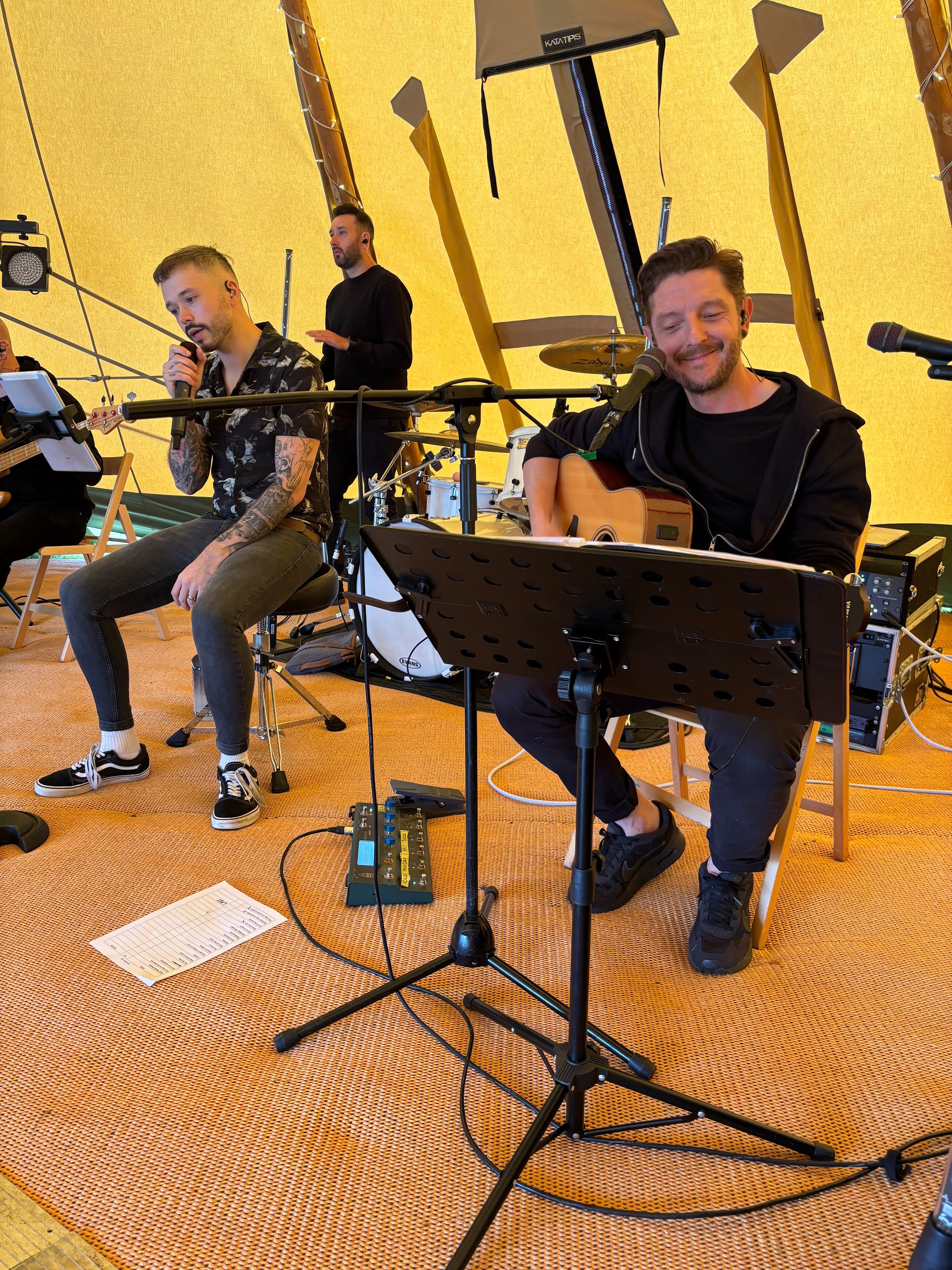 Two of the band playing the acoustic set, seated with guitars
