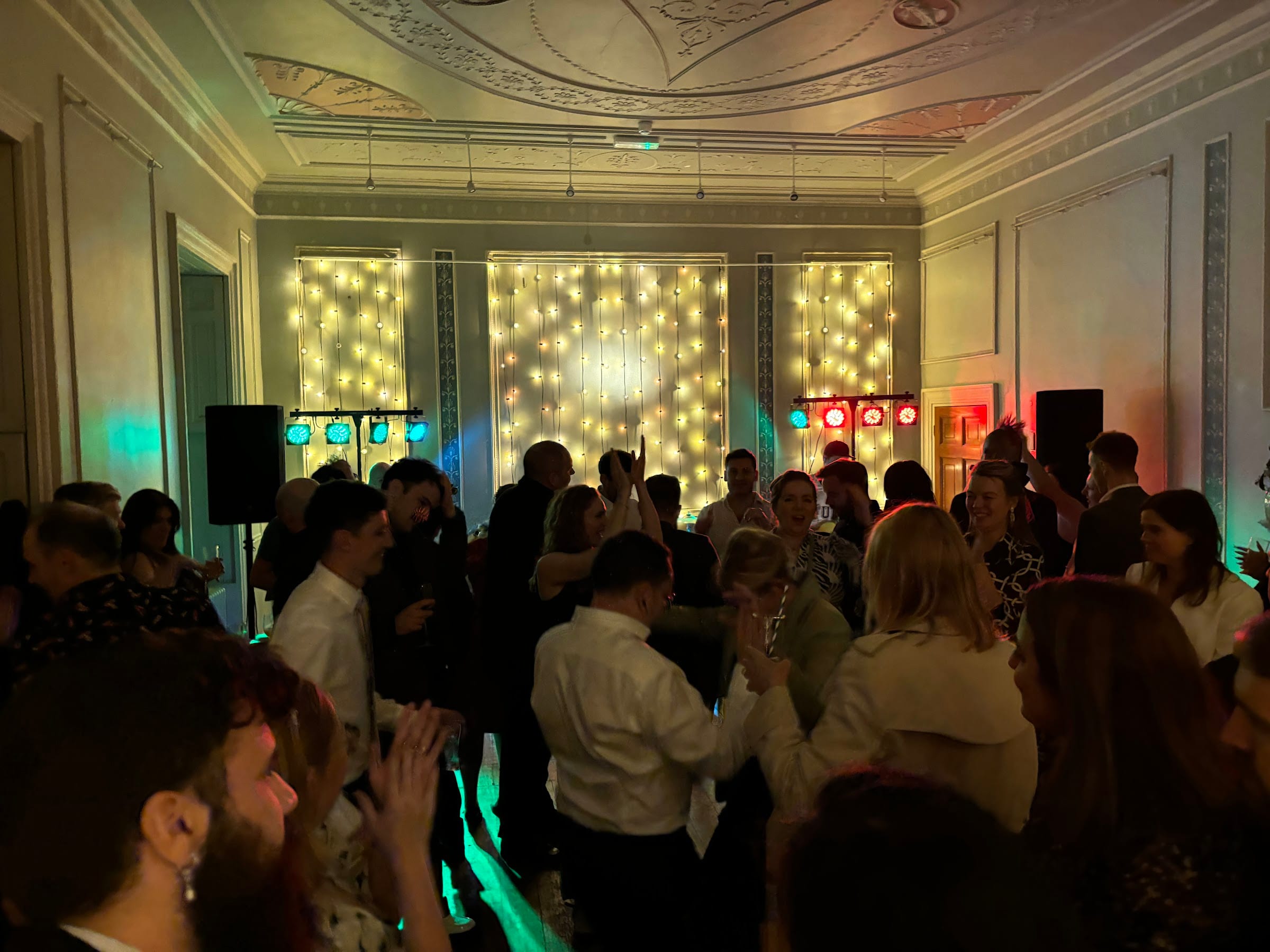 Guests dancing in front of a wall of fairy lights